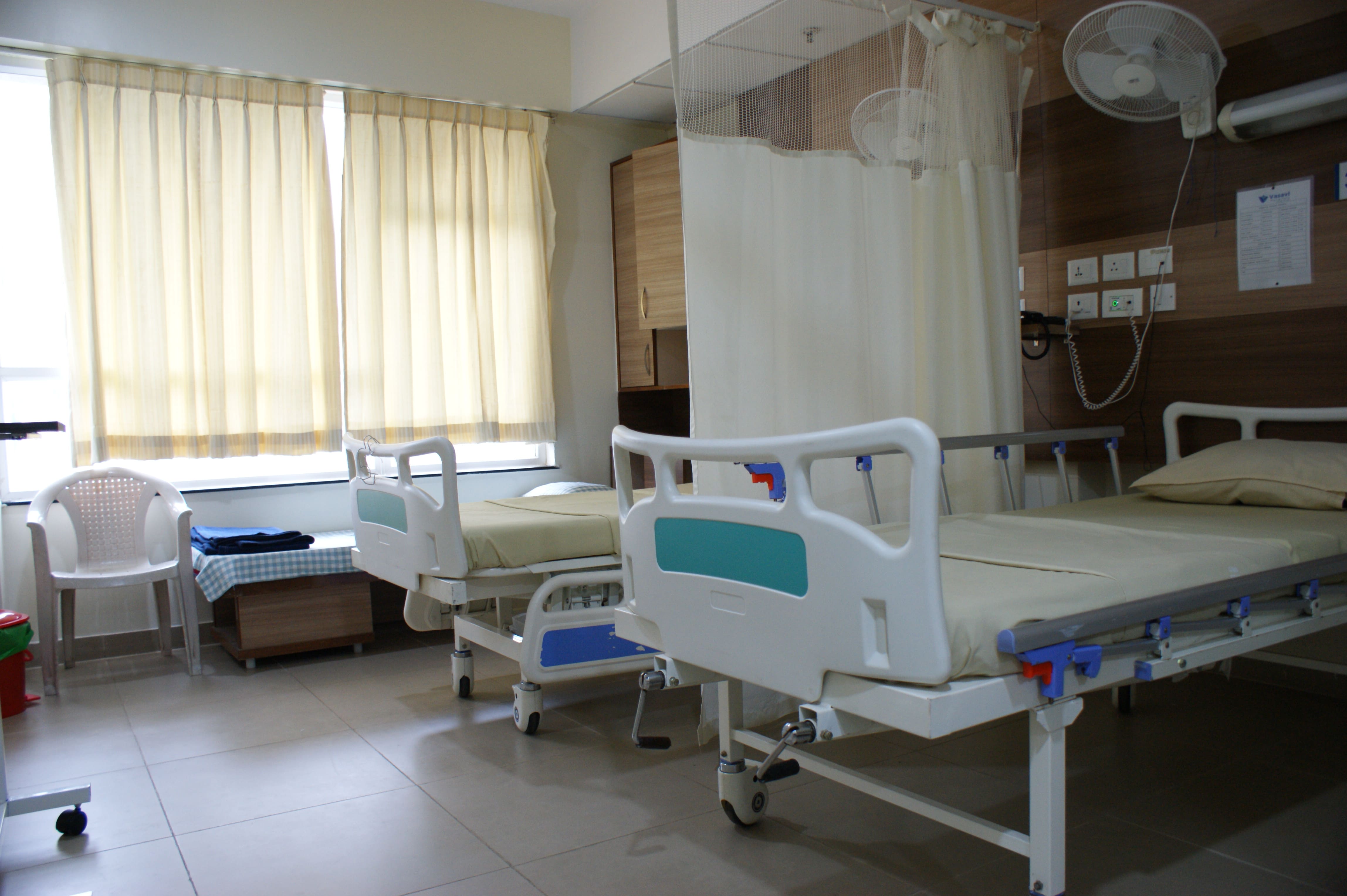 Twin sharing hospital room at Vasavi Hospitals Bangalore with advanced facilities and natural lighting.